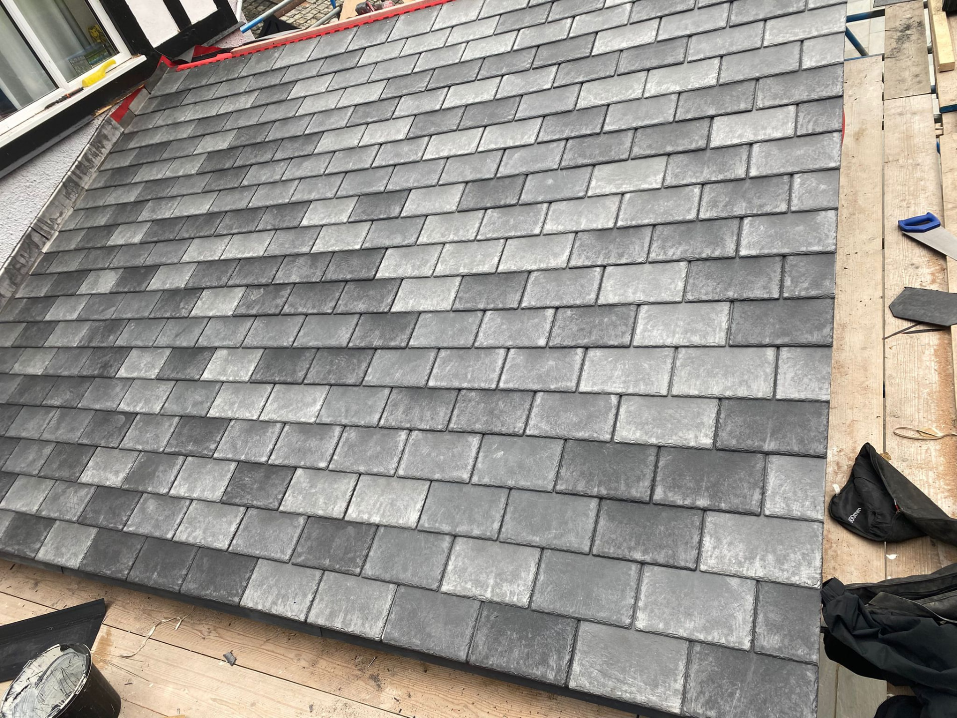 Completed natural slate roof with neat ridge tiles and lead detailing