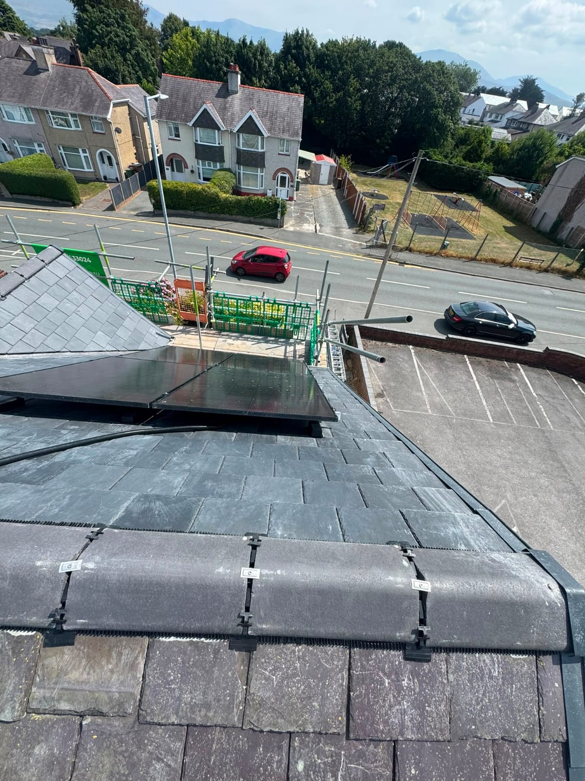 Completed natural slate roof with neat ridge tiles and lead detailing