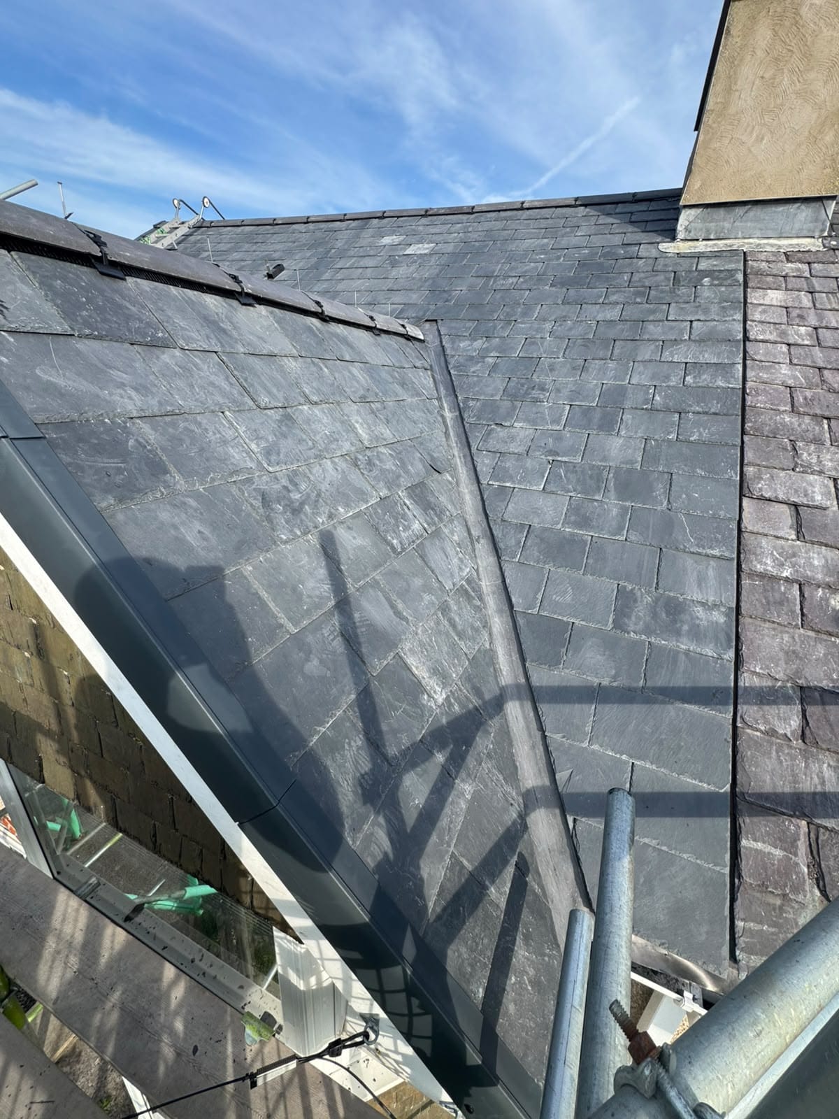 Completed natural slate roof with neat ridge tiles and lead detailing