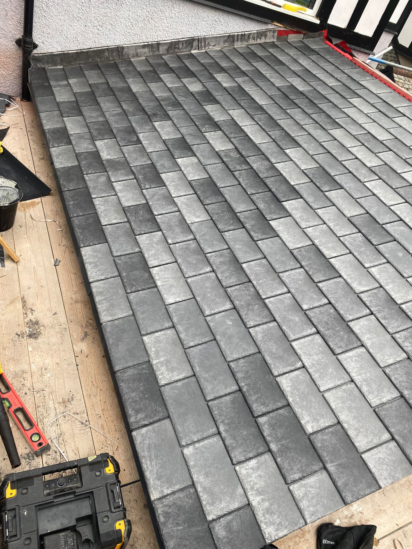 Completed natural slate roof with neat ridge tiles and lead detailing