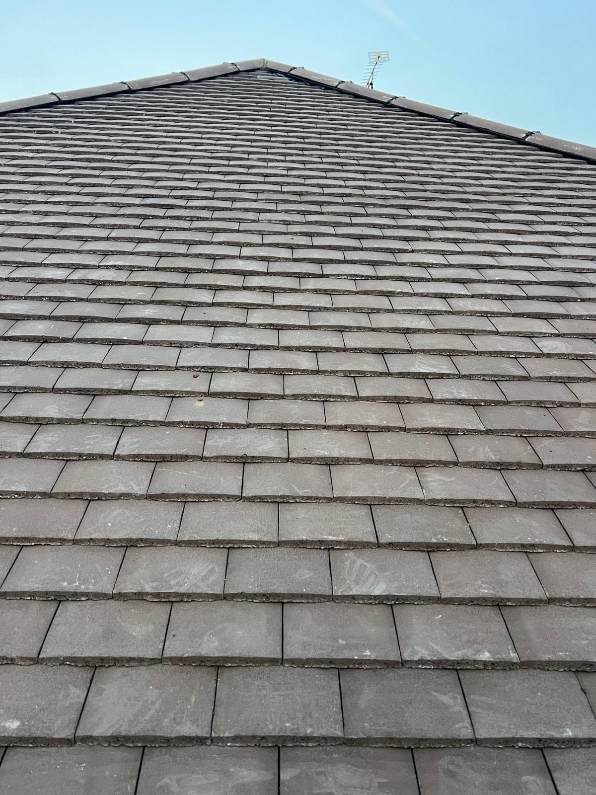 Close-up of a newly laid plain tiled roof with fresh ridge tiles