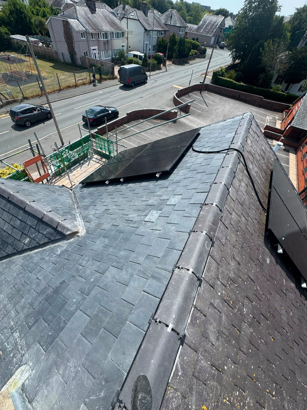 Completed natural slate roof with neat ridge tiles and lead detailing