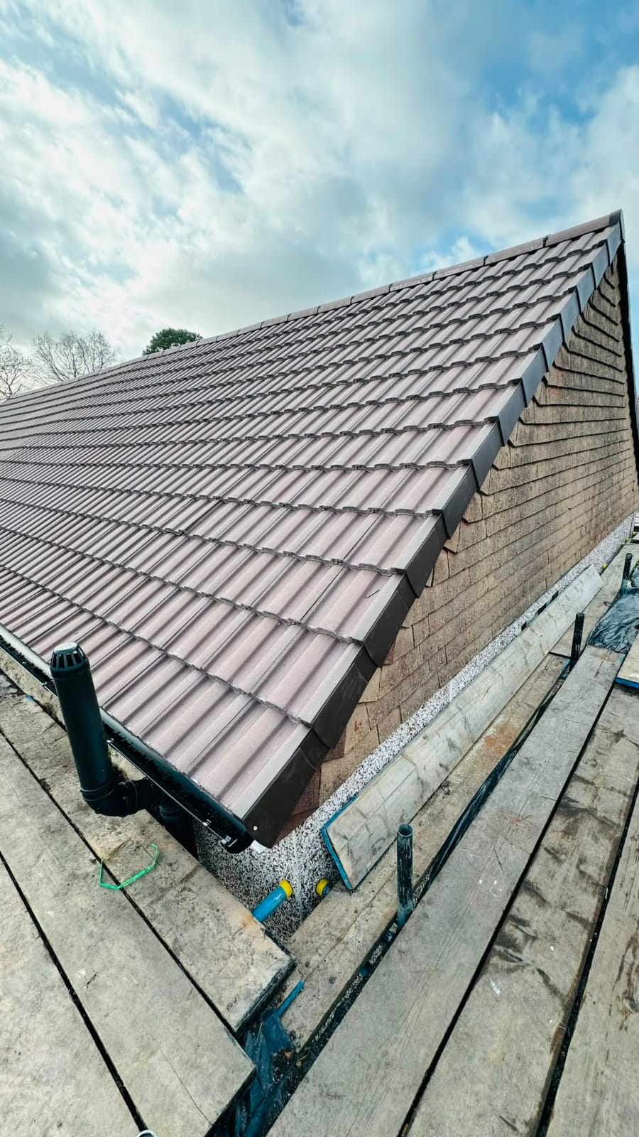 Finished concrete tiled roof with new ridge tiles on a house in North Wales
