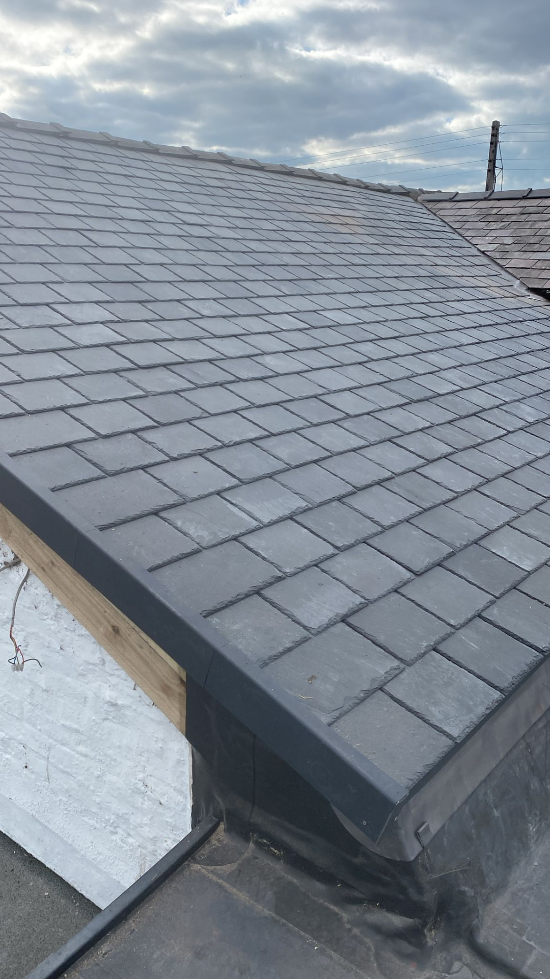 Repaired slate roof with new lead flashing and edge trim in North Wales