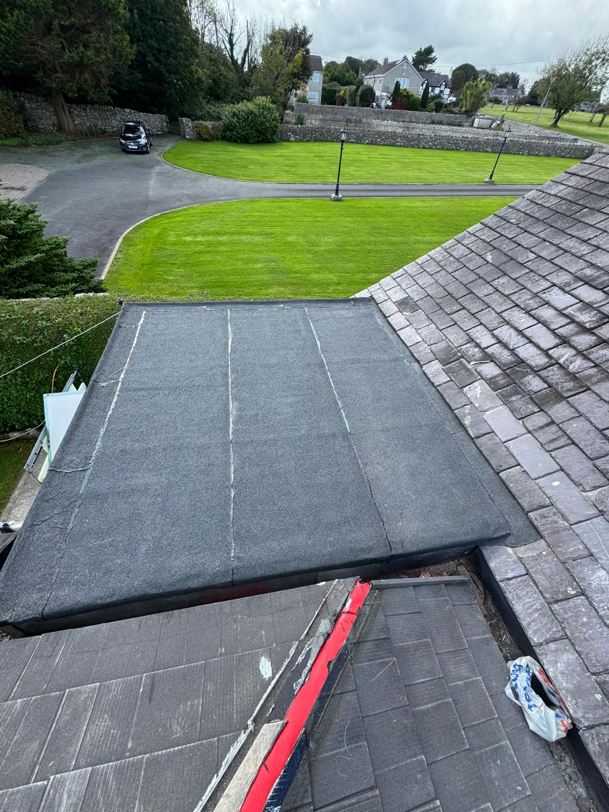 Completed flat roof replacement with clean seams and new edge trims
