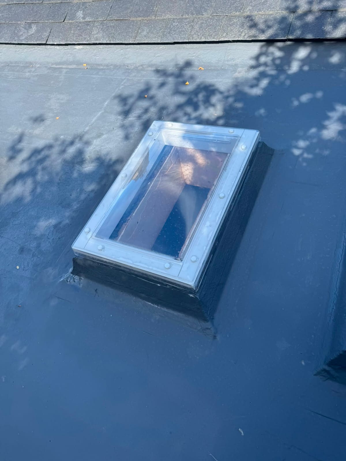 Rooflight sealed into a newly laid flat roof covering