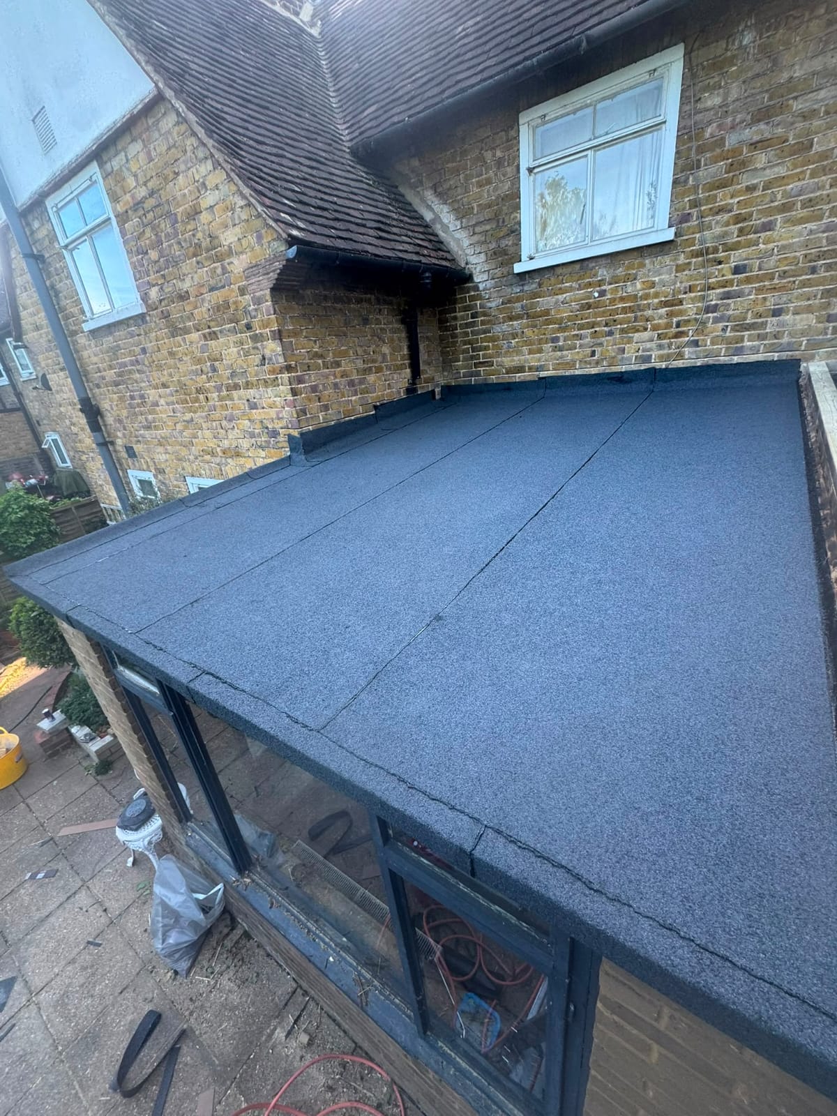 Completed flat roof replacement with clean seams and new edge trims
