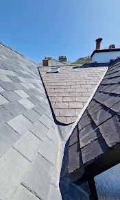 Completed natural slate roof with neat ridge tiles and lead detailing
