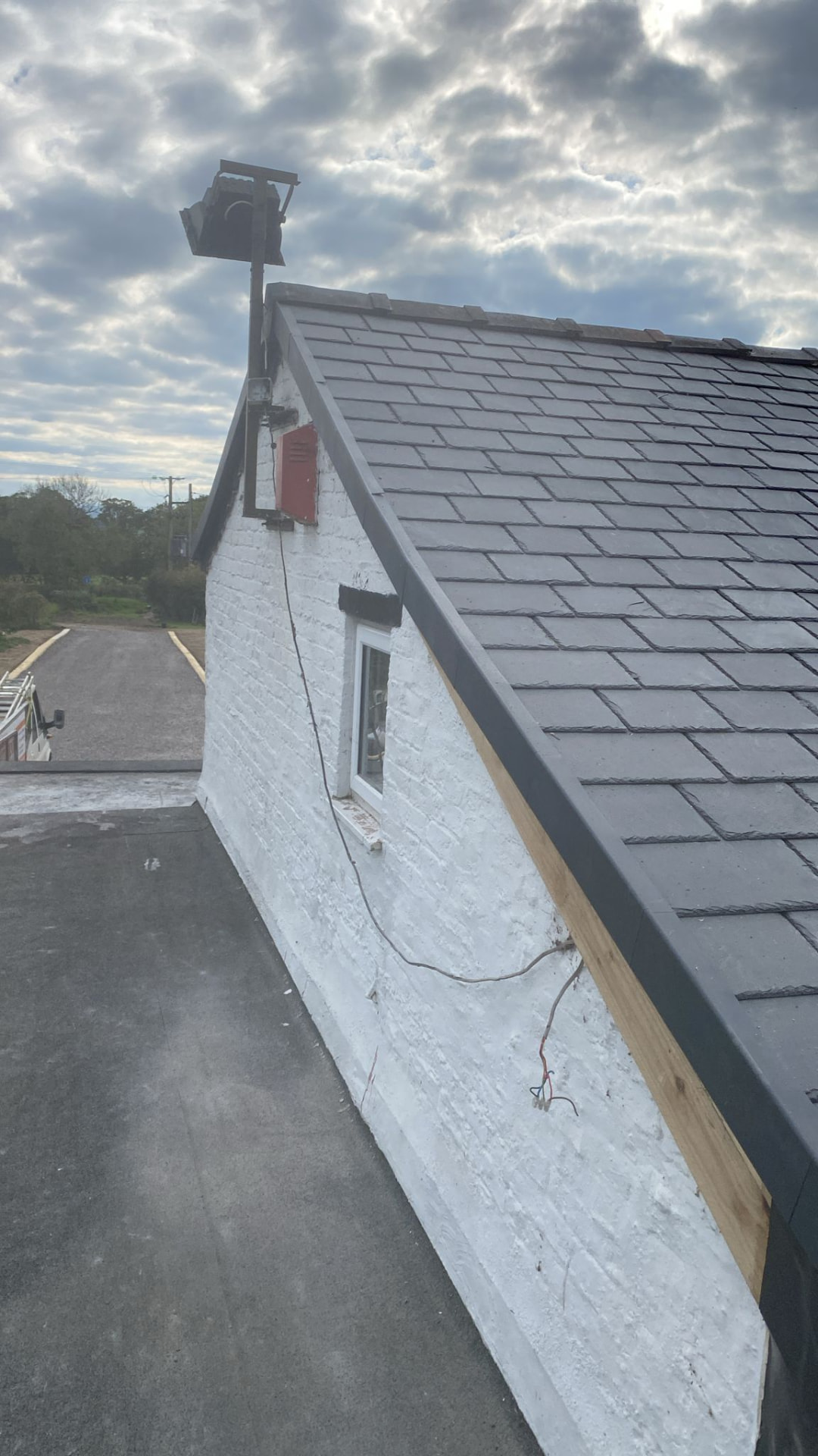 Completed natural slate roof with neat ridge tiles and lead detailing